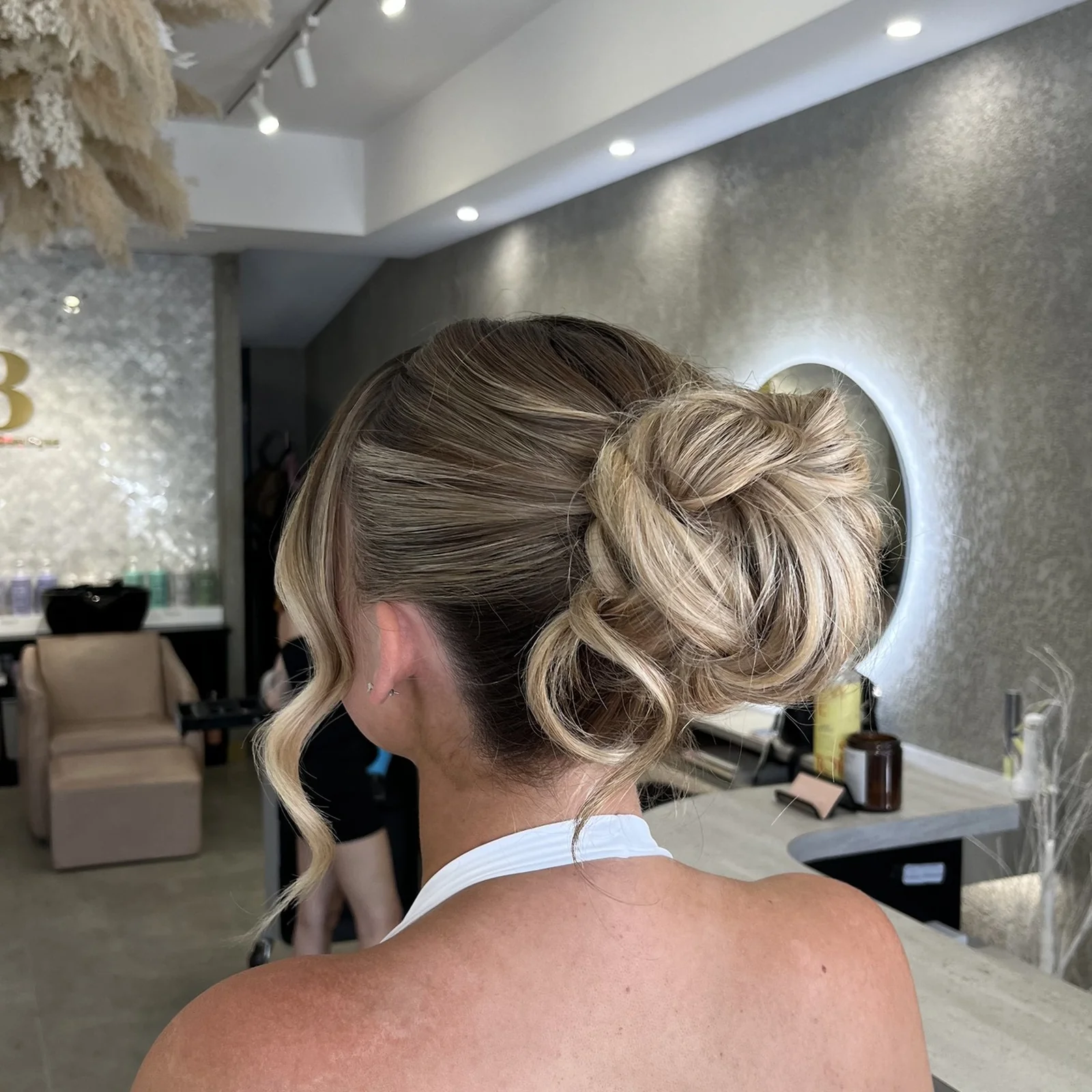 Textured low bun updo with blonde balayage